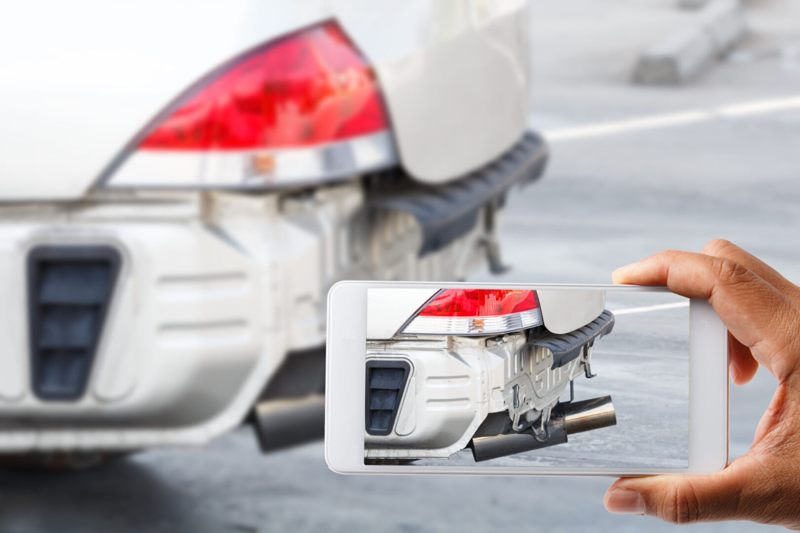 A Person Taking a Photograph of a Damaged White Car