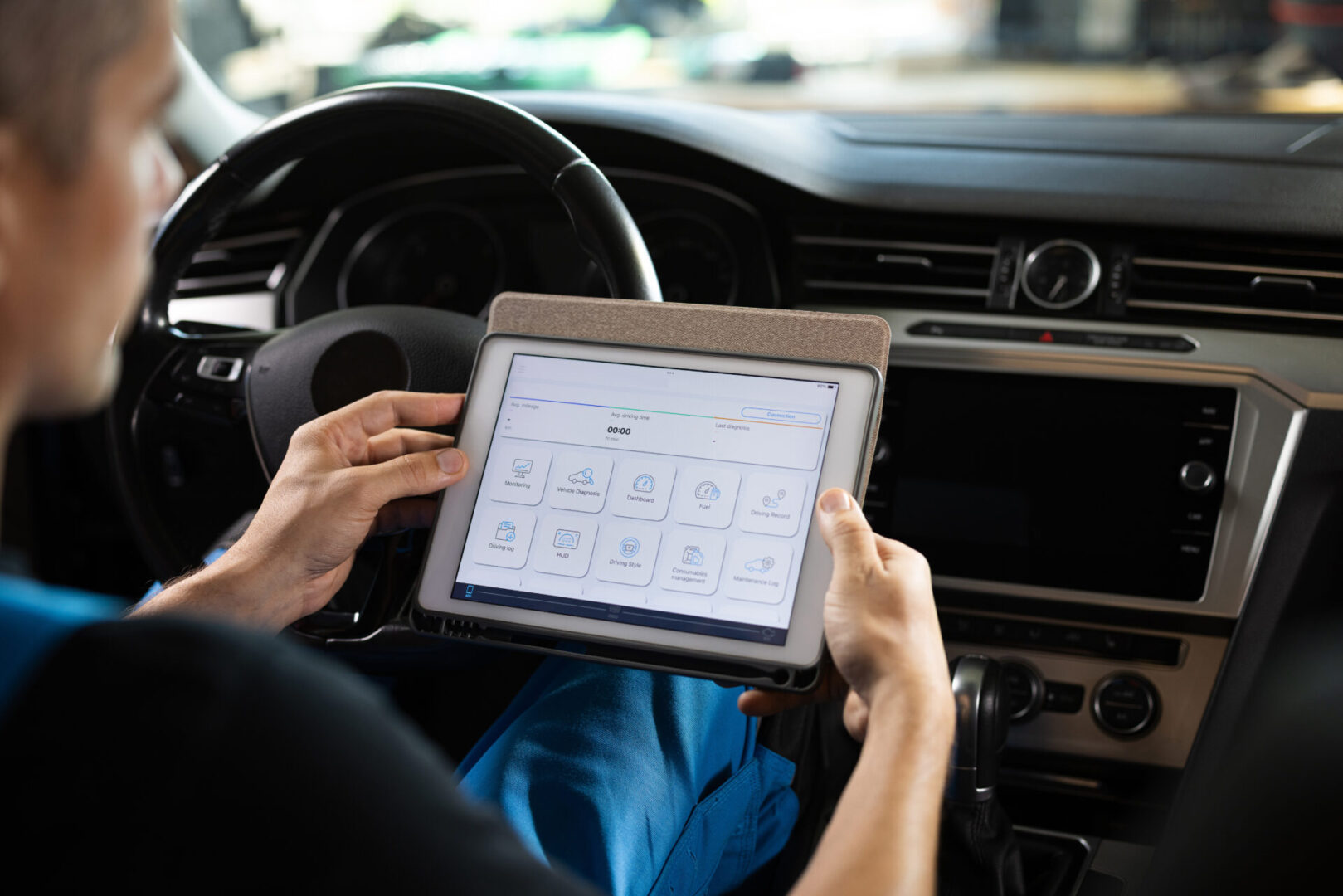 Automotive mechanic running diagnostics software on tablet. Unrecognizable vehicle service manager worker work in mechanics garage, check and maintenance to repair the engine car in workshop.